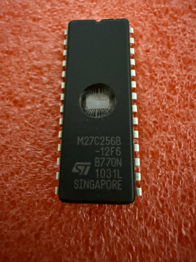 M27C256B-12F6 Microcontroller on a red textured background